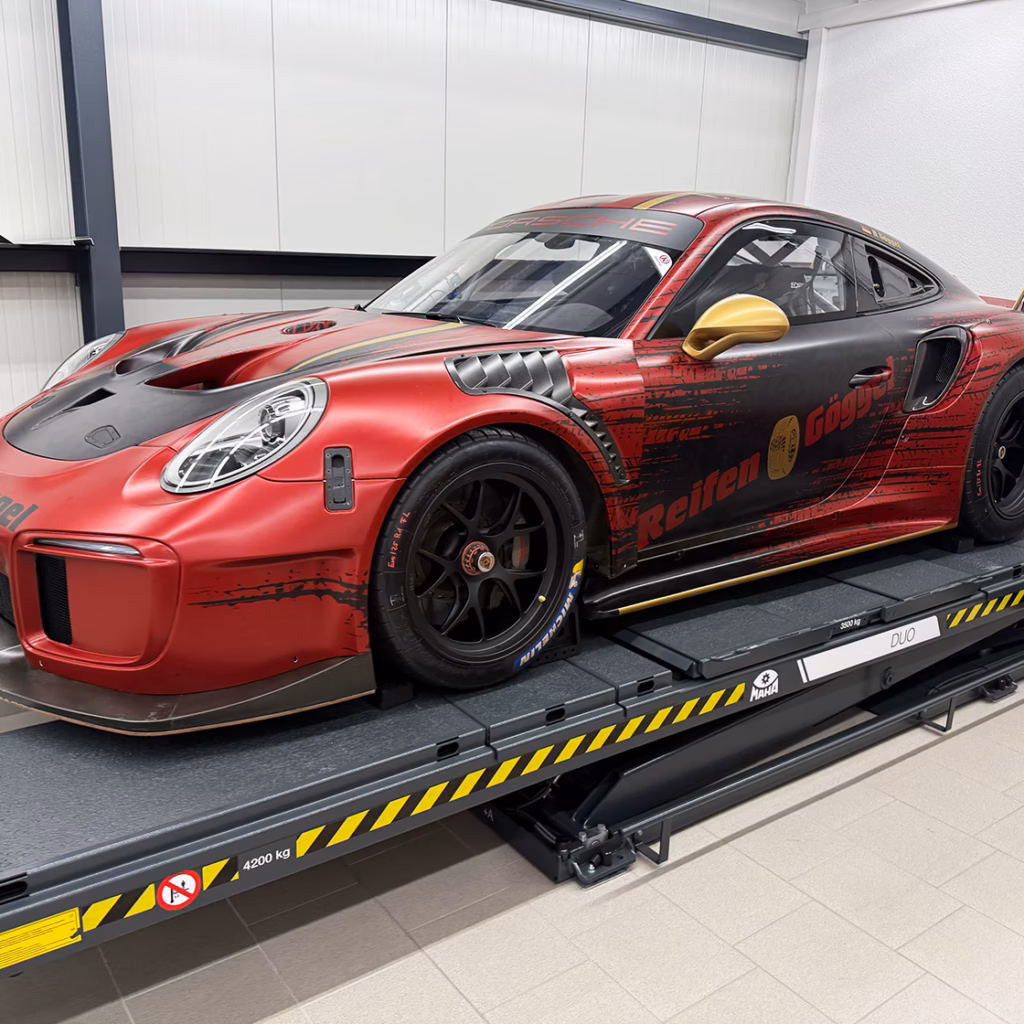 Rote Porsche 911 GT3 R während der professionellen Autofolierung im Studio.