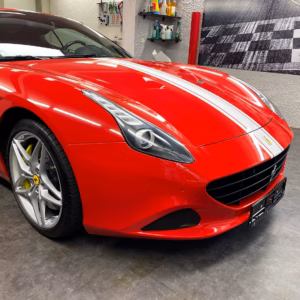 Präzise Handarbeit bei der Autofolierung an der Front eines Ferrari.