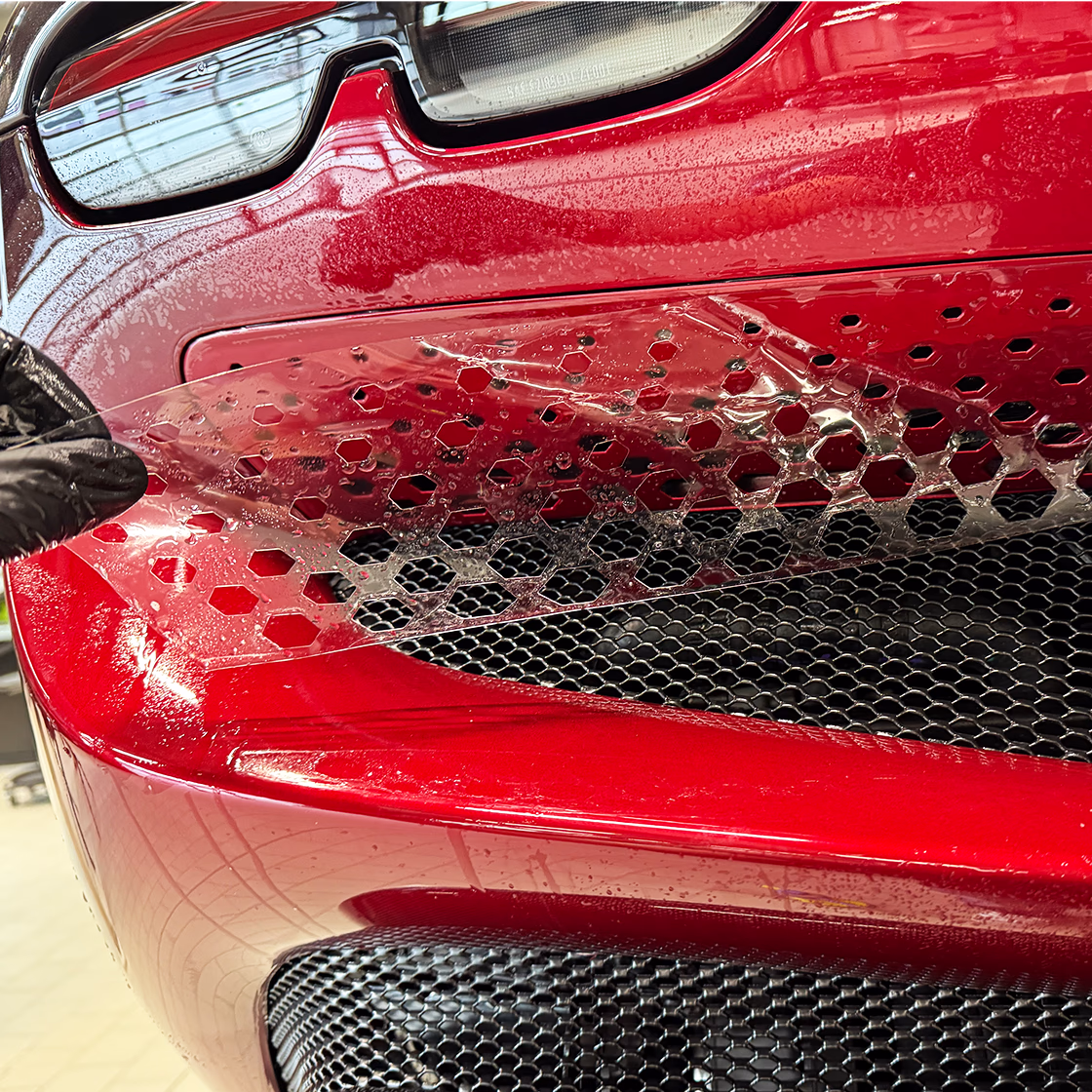 Glänzendes rotes Ferrari komplett mit Lackschutzfolie geschützt.